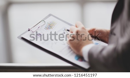 close up.businessman checking sales schedule.photo on blurred background