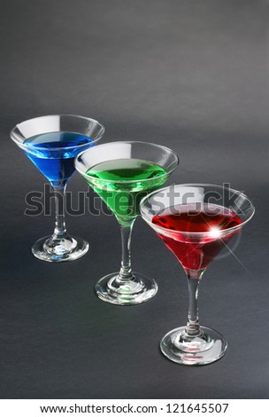 blue, green and red cocktails on black background