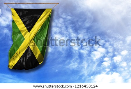 Flag of Jamaica. Vertical flag, against blue sky with place for your text