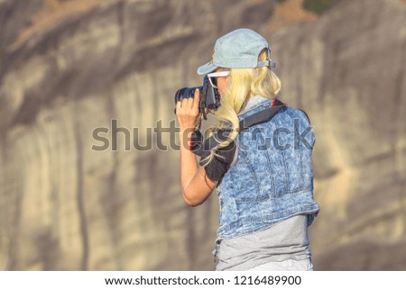 Traveler woman photographer with reflex camera at monasteries of Meteora in Central Greece, Europe. Caucasian female photographing a popular greek landmark.