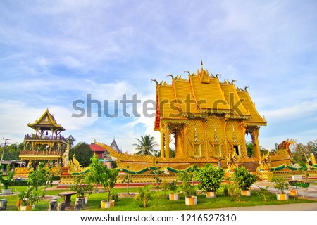 Wat Ban Nong Hu Ling is a golden temple. Around the temple there is a green lawn. The temple is located in Mahasarakham Province in Thailand.