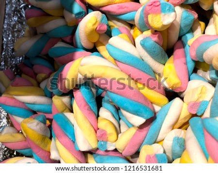The picture shows red, blue, yellow and white candies of different shapes from the candy store.