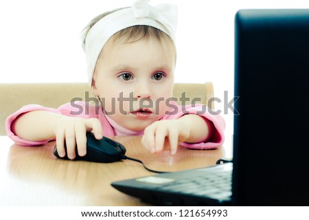 Cute baby looking into the laptop on a white background.