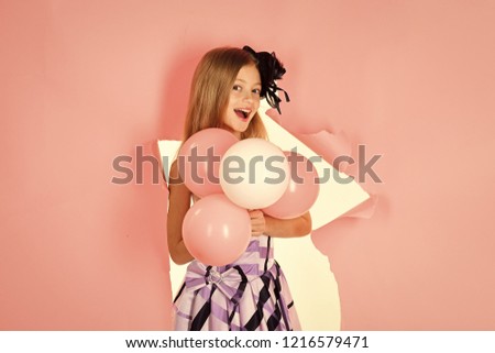 Little girl with balloons on a pink background