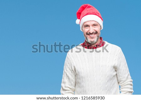 Middle age hoary senior man wearing christmas hat over isolated background with a happy and cool smile on face. Lucky person.