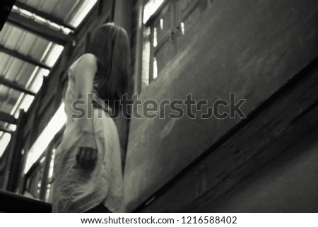 Horror scene of a mysterious woman in white dress. horror woman ghost standing on staircase in an abandoned asian house. Horror Halloween concept.