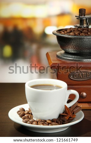 cup of coffee, grinder and coffee beans in cafe