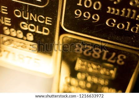 Fine solid gold 999.9 one ounce bullion ingot precious metals bar closeup isolated photo.