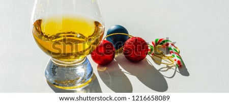 single malt whiskey glass with candy cane and Christmas balls, the symbol of Christmas holiday, Xmas set decoration