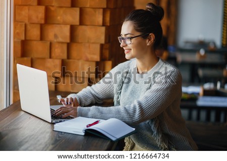 brunetter woman working on her laptop at a restaurant Royalty-Free Stock Photo #1216664734