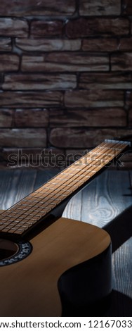 A ray of light illuminates a guitar lying in the dark.
