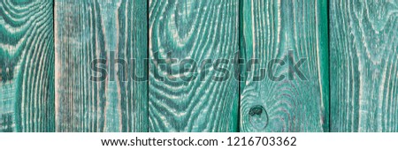 Background of wooden texture boards with a rest of paint of green color. Vertical. Narrow.