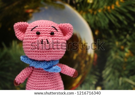 Knitted toy piggy on christmas decorations background. Chinese new year of the Pig, symbol 2019, Zodiac sign for greetings card