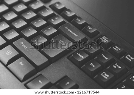 A close up black and white photo of a computer keyboard. Information technology concept image. 