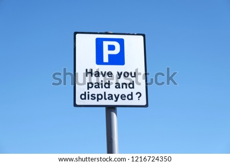 Paid and displayed car park sign against blue sky