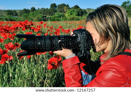 professional woman photographer in a field with poppies