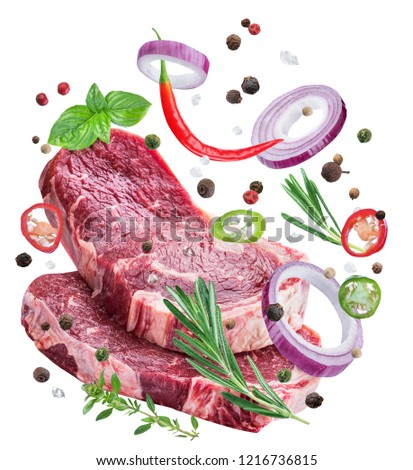 Falling down meat steaks and spices. Flying motion effect of cooking process. File clipping path.