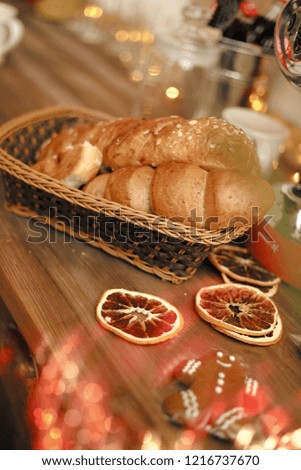 New Year's home interior. Garlands in bokeh. Beautiful red and white plates and cups on a wooden table. Cozy atmosphere. Christmas mood.