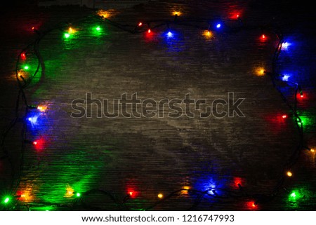 multicolored Christmas lights on a wooden background
