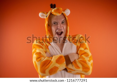 pajamas in the form of a giraffe. emotional portrait of a guy on an orange background. crazy and funny man in a suit. animator for children's parties
