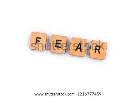 FEAR, spelt with wooden letter tiles over a plain white background. 