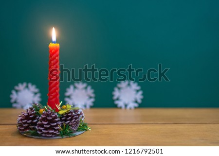 decoration with red candles and Christmas tree cones on wooden table
