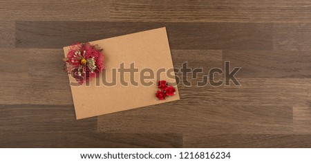 Envelope. Brown envelope with Red flowers on wooden background, Love letter composition, top view, copy space
