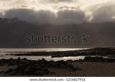 textured cloudy sky over a cliff on the ocean at dawn