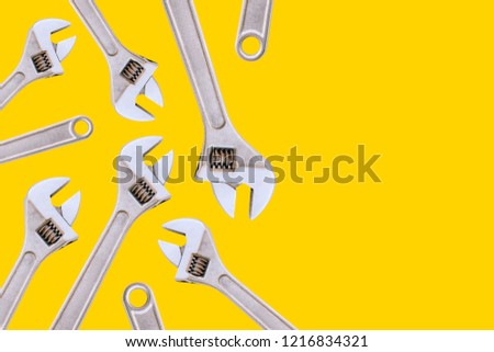 Adjustable wrench. Tools on a yellow background