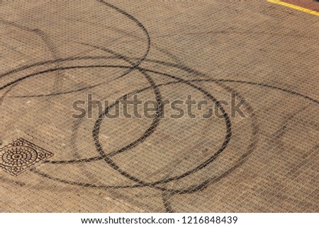 Abstract transport background with pivoting black tire track over asphalt road surface. Trace of drift, braking rubber tire, black track. Abstract road background with intersection of tires from drift