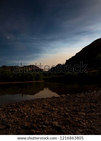 A basic long exposure photo sitting under the night sky and camping next to the river bed