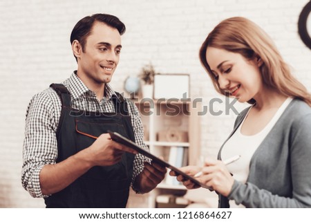 Courier Delivery. Man with Tablet. Worker Man Arab Nationality. White Interior. Master Arab Nationality. Courier in Blue Clothes. Express Repairs. Smiling Girl Sign. Woman Client Signs Act Work.