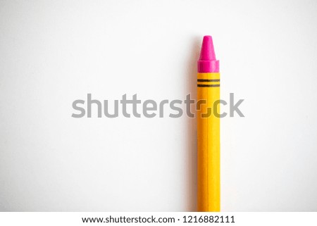 Pink crayon shot close up on a white background