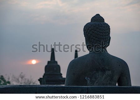 Buddha statue and the sun rise at Borobudur temple.
