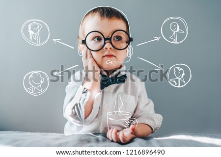 Cute little genius. Baby boy wearing smart outfit and eye glasses working as call center operator answering several people and drinking imaginery coffee. Children and technologies concept. 