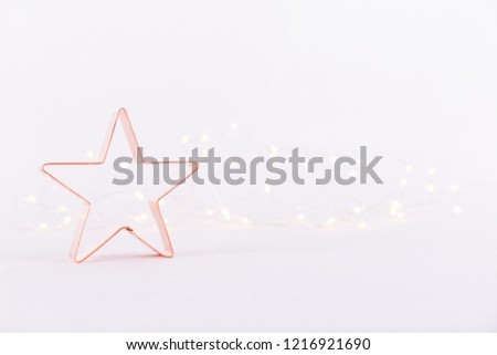 Star Copper cookie cutter on white sparkling background with bokeh lights. Holiday Christmas and New Year background. Horizontal