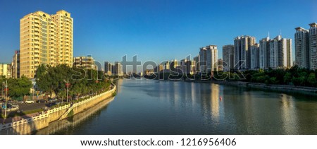 As a merged panorama, this photo provided a wide-angle view of urban landscape of the Xi'zhi River in Huizhou, China at the golden hour in autumn. 