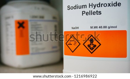 Bottle of Sodium Hydroxide, NaOH with Properties information and its chemical hazard warning symbols. Corrosive hazard symbol, Inhalation hazard symbol. Royalty-Free Stock Photo #1216986922