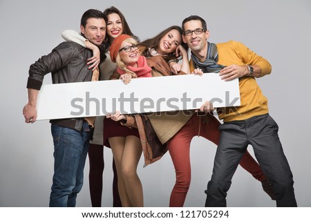 Group of young friends with advert board