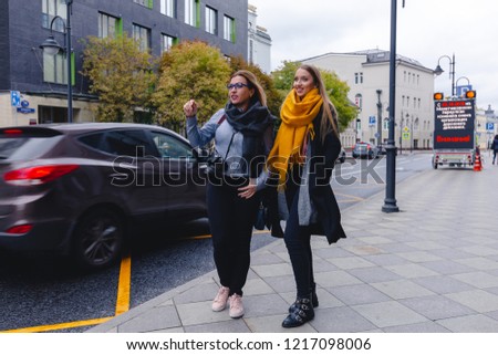 A trip to Russia in the fall. Two friends are walking in the historical center of Moscow. Blondes with long hair on a street photo shoot.