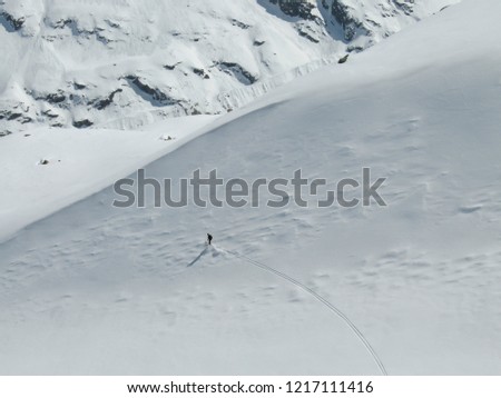 backcountry skier enjoying a deep powder ski descent in the high Alps of Switzerland in deep winter near Morteratsch in the Engadine Valley