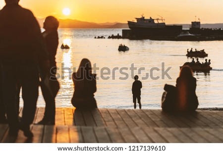 Silhouettes of people at sunset on the sea.