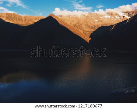 Mountains in Vaujany village in France, ski resort with lake view in sunset