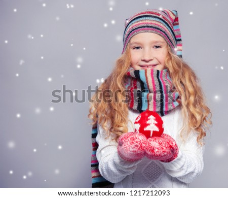 Girl in winter clothes with christmas ball