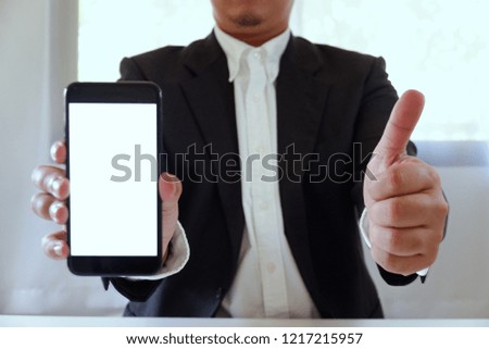 Businessman holding smartphone forward empty white screen for your text or picture
