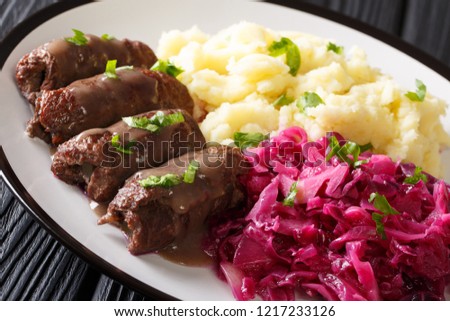 Beef Rouladen or Rinderrouladen German classic dish served with mashed potato and red cabbage close-up on a plate. horizontal
