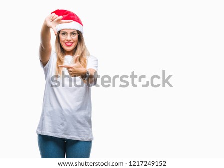 Young beautiful woman wearing christmas hat over isolated background smiling making frame with hands and fingers with happy face. Creativity and photography concept.