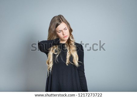 beautiful blond woman with neck pain, isolated over black background
