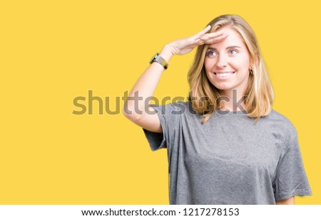 Beautiful young woman wearing oversize casual t-shirt over isolated background very happy and smiling looking far away with hand over head. Searching concept.