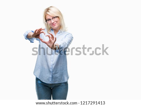 Young beautiful blonde business woman wearing glasses over isolated background smiling in love showing heart symbol and shape with hands. Romantic concept.